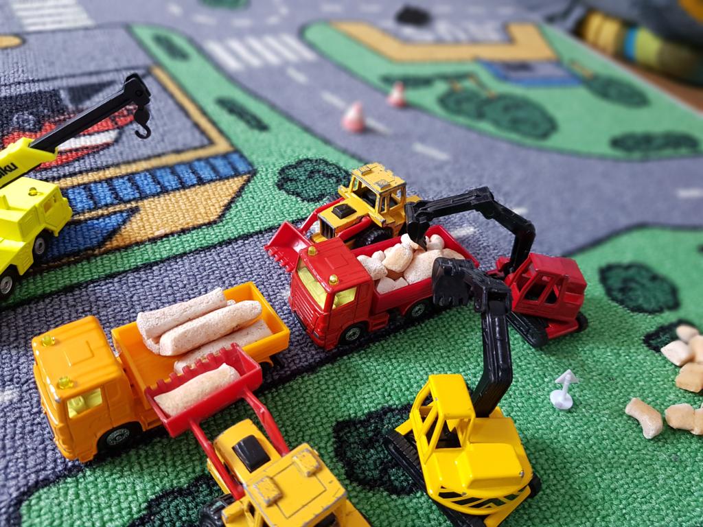 Bauarbeiten durch Spielzeugautos ähnlich dem Geschäftsmodell der Hochtief AG